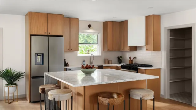 a kitchen with a table chairs refrigerator and cabinets