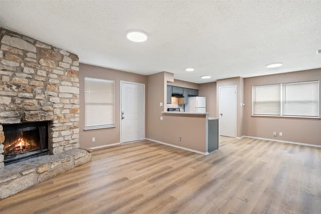 a view of empty room with wooden floor and fireplace