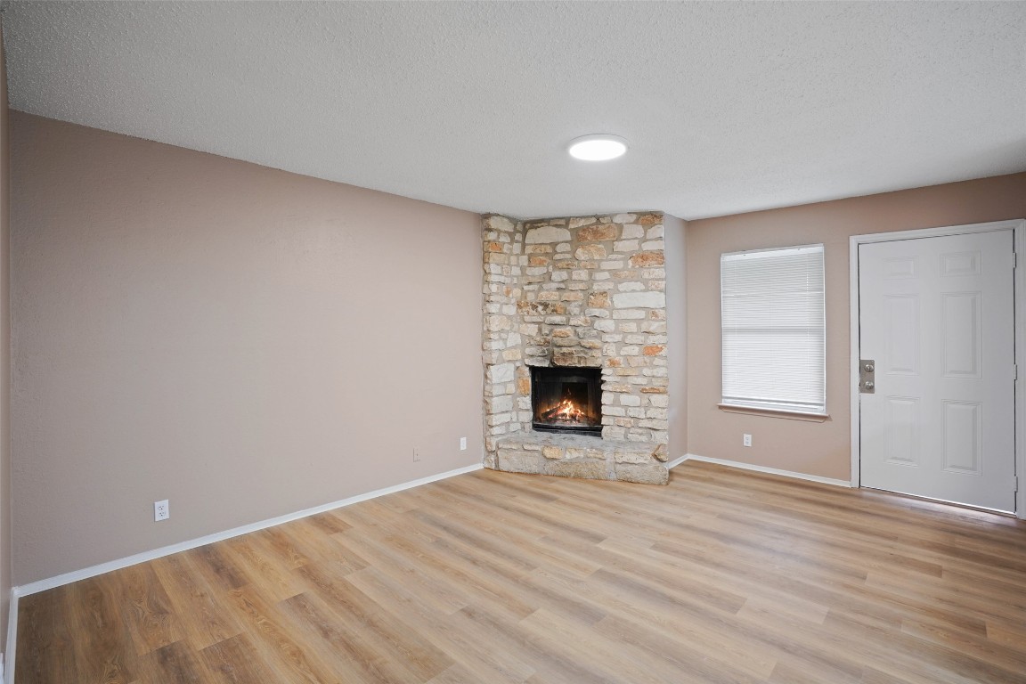 2312 Rachael Court, Unit C Austin, TX 78748 - Photo 2 of 13 a view of empty room with wooden floor and fireplace