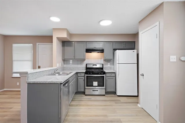 a kitchen with a sink stove and refrigerator