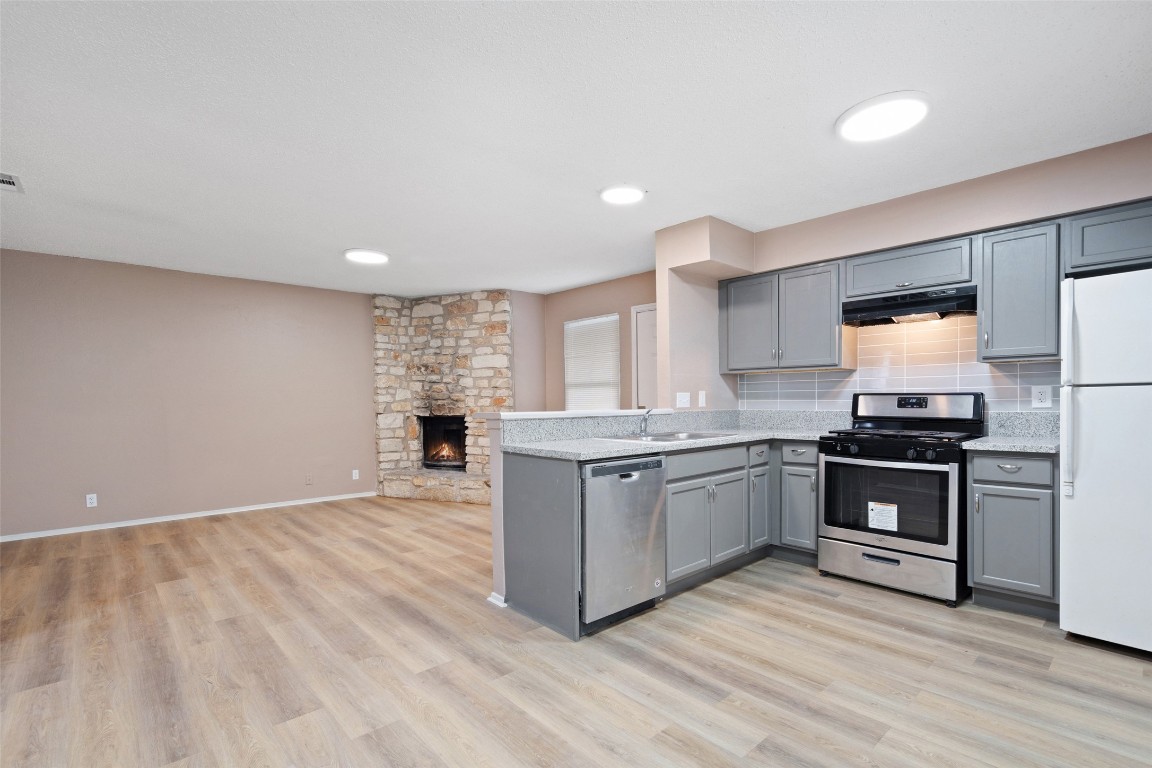 2312 Rachael Court, Unit C Austin, TX 78748 - Photo 5 of 13 a kitchen with granite countertop a stove top oven and cabinets