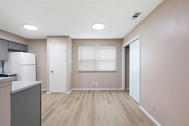 a view of a room with wooden floor and electronic appliances