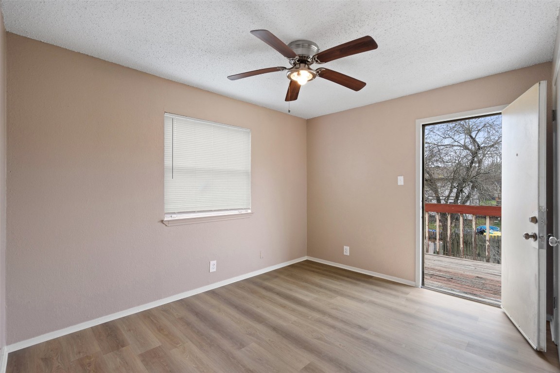 2312 Rachael Court, Unit C Austin, TX 78748 - Photo 8 of 13 an empty room with wooden floor fan and windows