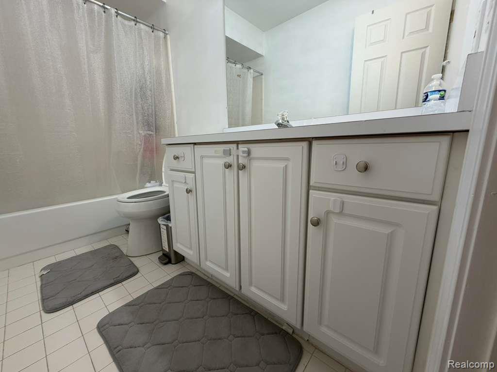 1154 Bluebird Drive Rochester, MI 48307 - Photo 16 of 34 Bathroom featuring a white vanity with panel cabinetry and silver-tone hardware, a solid surface countertop, and a built-in sink