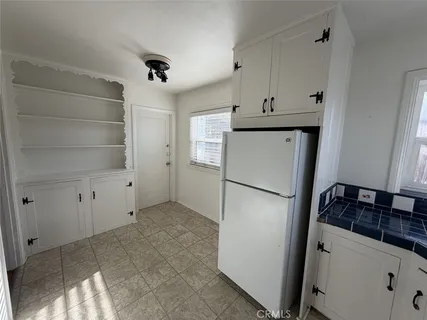 a kitchen with a refrigerator and a stove top oven