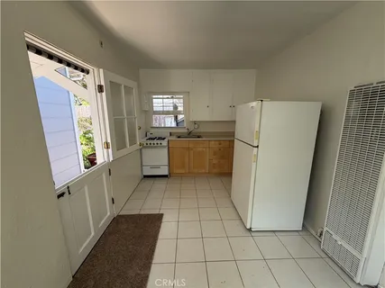 a kitchen with a refrigerator a stove top oven and cabinets