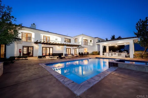 a view of a house with swimming pool and sitting area