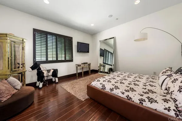 a bedroom with a bed and wooden floor