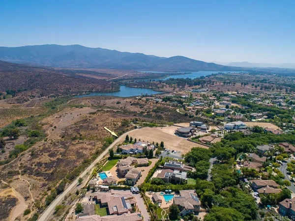 an aerial view of residential houses with outdoor space and trees