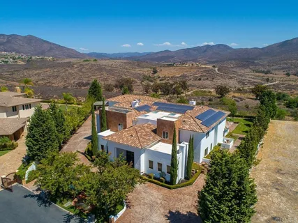 an aerial view of a house with swimming pool and sitting area