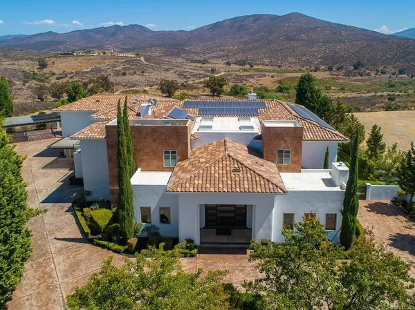 an aerial view of a house with a garden and lake view