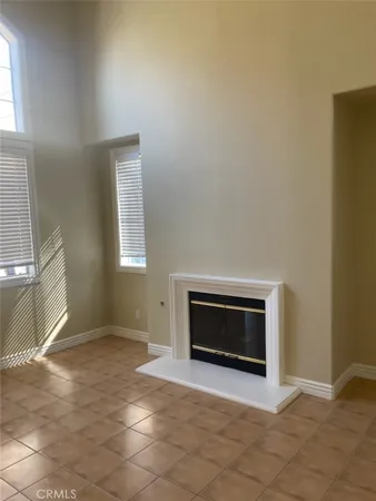 a view of an empty room with a fireplace and a window