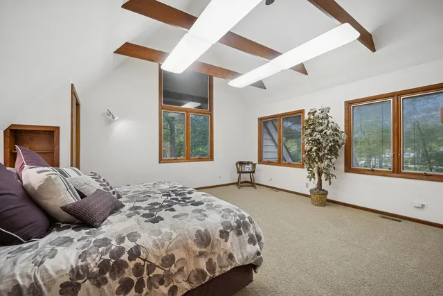 a bedroom with a bed and a large window