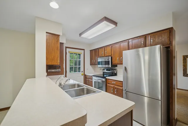 a kitchen with stainless steel appliances a refrigerator stove microwave and sink