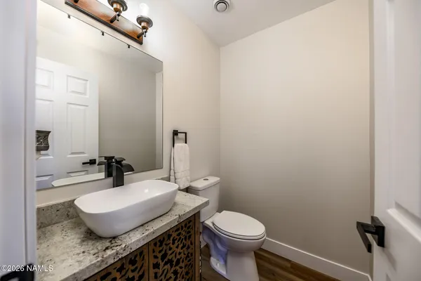 a bathroom with a granite countertop sink a large mirror and a toilet