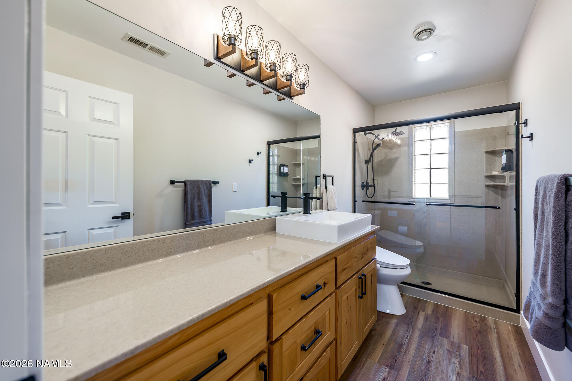 4540 Forest Ranches Loop Parks, AZ 86018 - Photo 25 of 60 a bathroom with a granite countertop sink a large mirror and a toilet