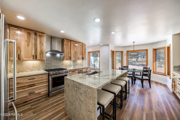 a kitchen with stainless steel appliances granite countertop a kitchen island hardwood floor sink stove and granite counter top