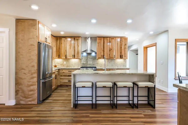 a kitchen with stainless steel appliances granite countertop a stove refrigerator sink and cabinets