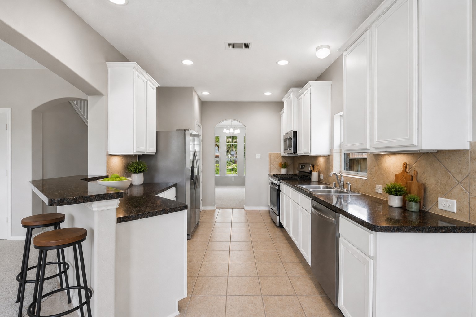 25926 Morgan Springs Spring, TX 77373 - Photo 12 of 49 The spacious kitchen is designed for both everyday living and entertaining, featuring abundant cabinetry, expansive granite countertop space, a breakfast bar, under-cabinet lighting, gas cooking, and a walk-in pantry, all while opening to the family room. All new appliances included! **Photo is Virtually Staged**