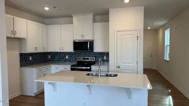 a kitchen with a sink a stove and a cabinets