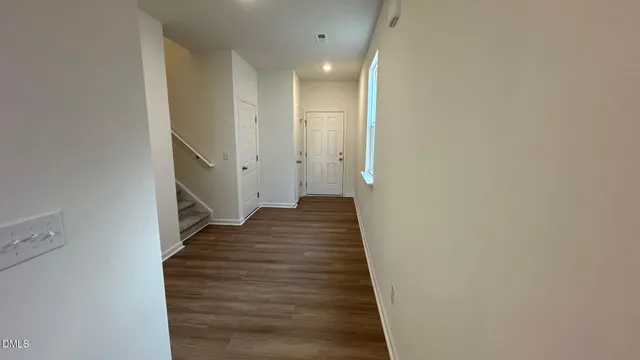 a view of a hallway with wooden floor and staircase