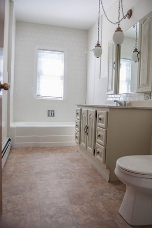 8-10 Kimball Road Watertown, MA 02472 - Photo 17 of 20 a bathroom with a granite countertop sink a toilet and a bathtub