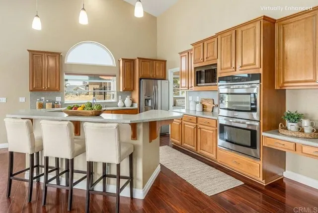 a view of an empty room with wooden floor and a ceiling fan