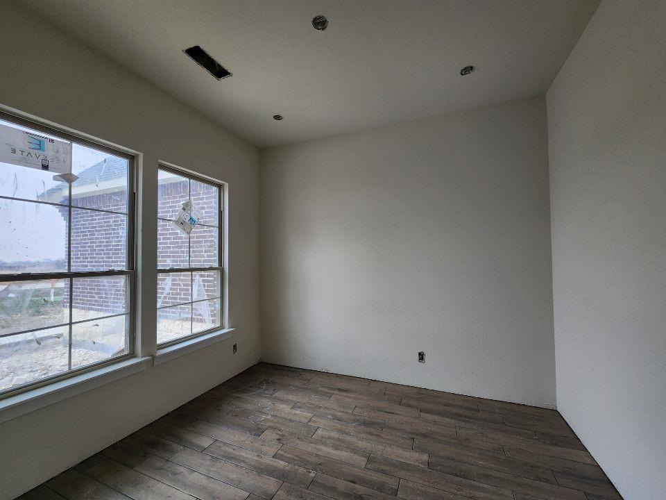 2433 Meteor Drive Krum, TX 76249 - Photo 4 of 12 a view of an empty room with a window and wooden floor