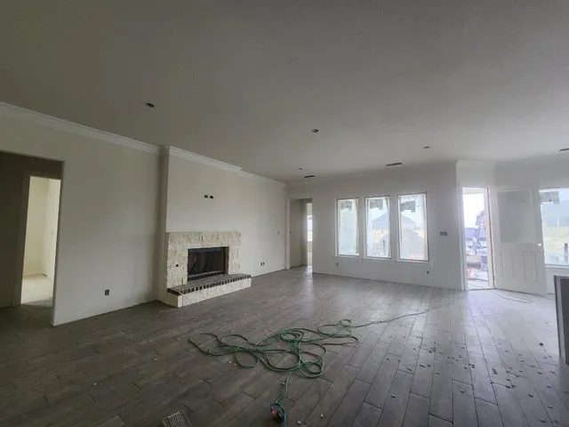 a view of a livingroom with wooden floor and a fireplace
