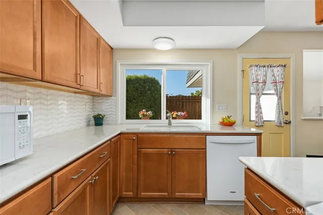a kitchen with stainless steel appliances granite countertop a sink and a wooden cabinets
