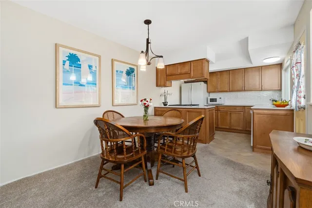 a kitchen with a dining table chairs and white cabinets