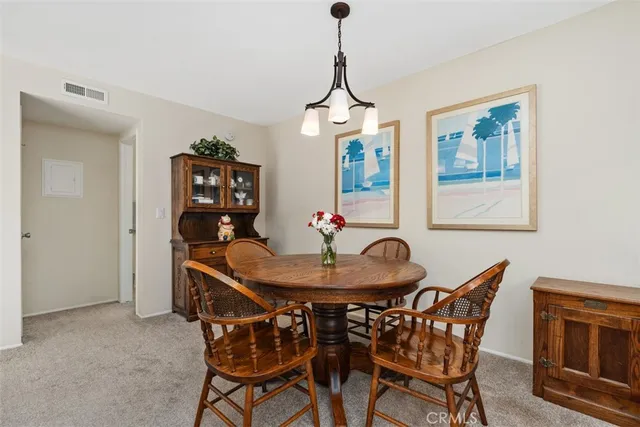 a dining room with furniture a chandelier and wooden floor