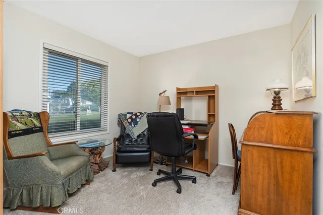 a view of a workspace with furniture and a window