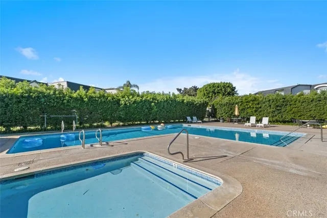 a view of a swimming pool with a patio and a yard