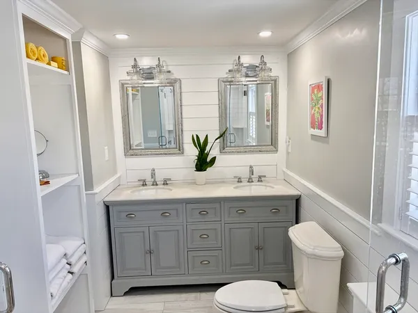 a bathroom with a granite countertop toilet sink and mirror