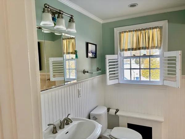 a bathroom with a sink a toilet and mirror