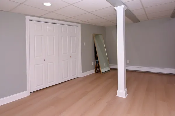 an empty room with a fireplace and a ceiling fan