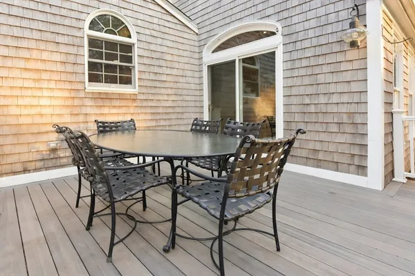 a patio with table and chairs and potted plants