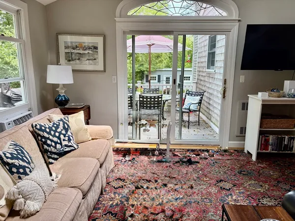 a living room with furniture a flat screen tv and a large window