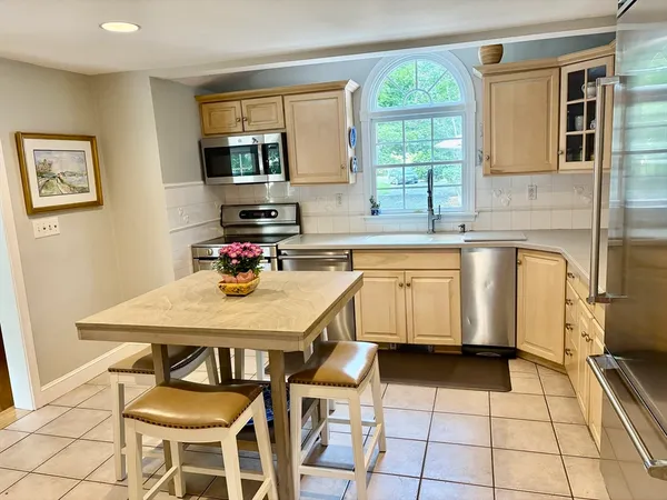 a kitchen with a table chairs sink and cabinets