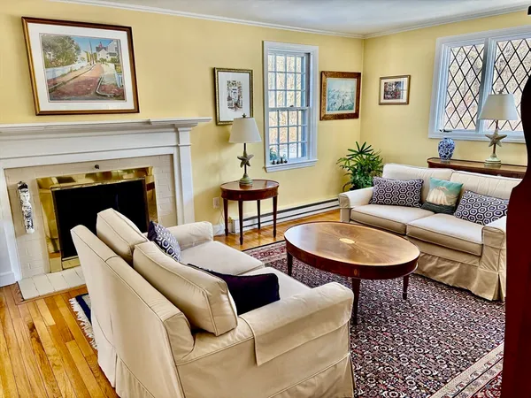 a living room with furniture a couch and paintings on the wall