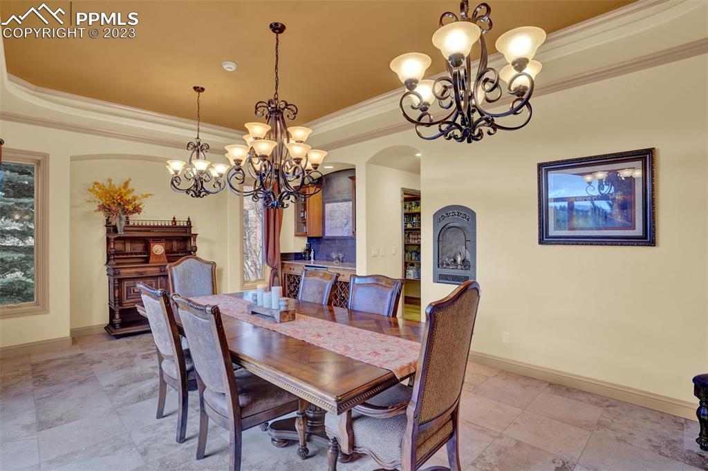 4655 Seton Hall Road Colorado Springs, CO 80918 - Photo 14 of 50 a dining room with wooden floor a chandelier a wooden table and chairs