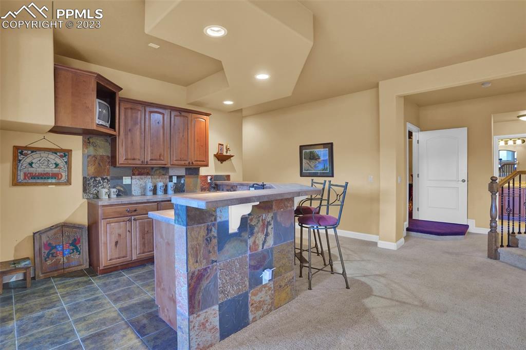 4655 Seton Hall Road Colorado Springs, CO 80918 - Photo 44 of 50 a kitchen with stainless steel appliances kitchen island granite countertop a table chairs sink and cabinets