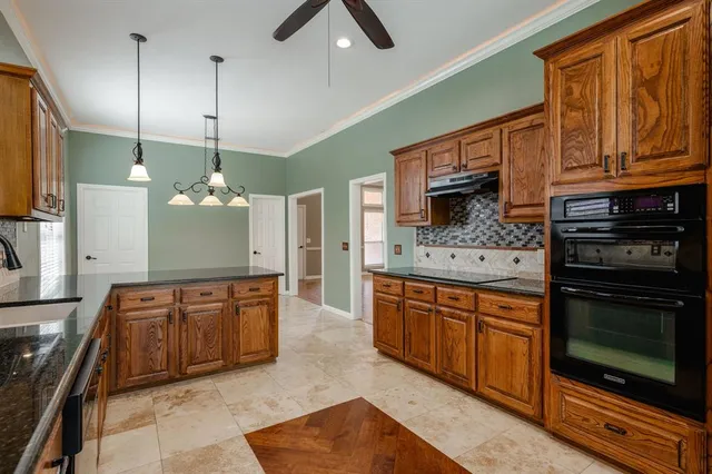 a large kitchen with stainless steel appliances granite countertop a stove a sink and a microwave