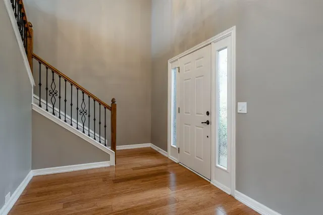a view of a hallway with wooden floor and staircase