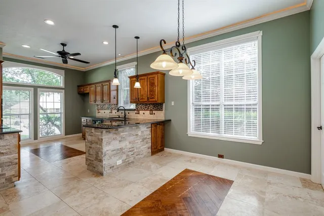 a large kitchen with kitchen island granite countertop a large window cabinets and stainless steel appliances