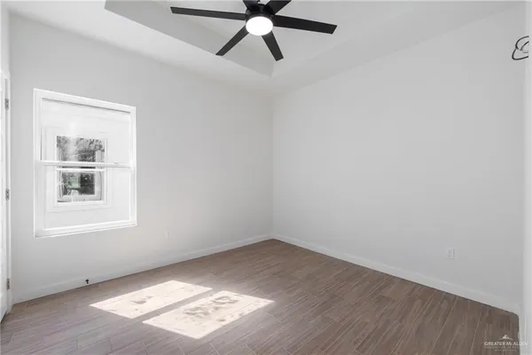 an empty room with a window and a fan