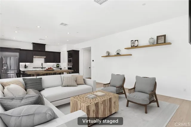 a living room with furniture and a view of kitchen