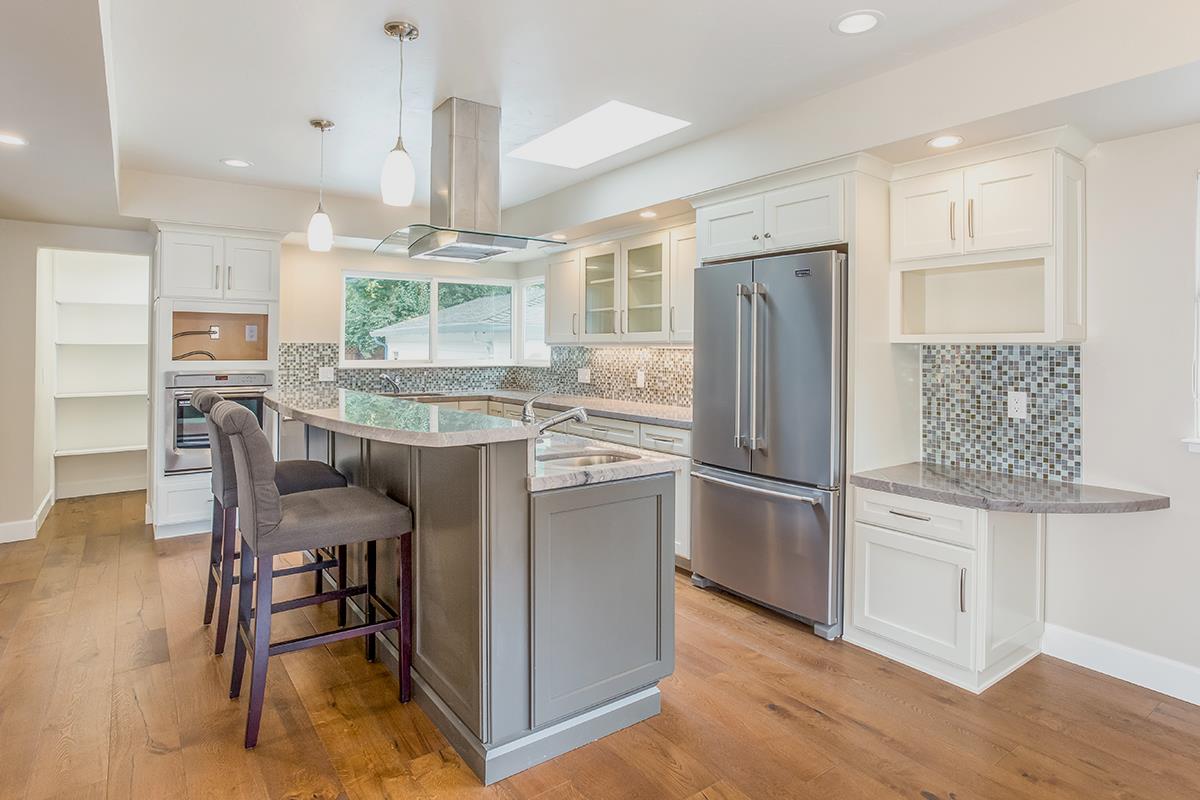 631 Riverside Avenue Santa Cruz, CA 95060 - Photo 3 of 25 a kitchen with kitchen island a dining table chairs refrigerator and wooden floor