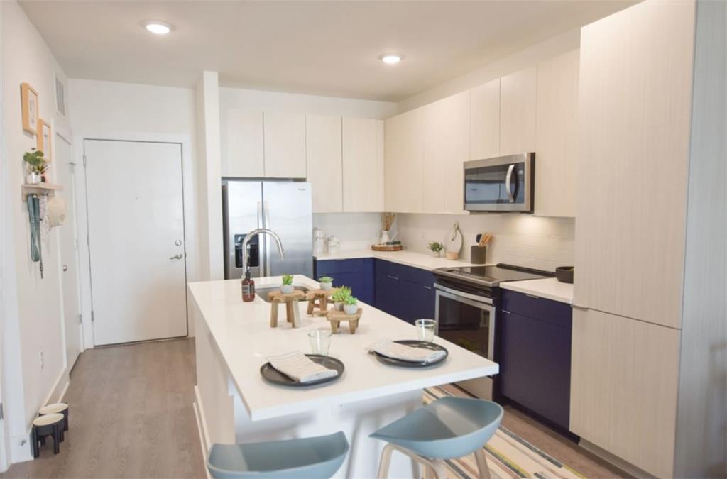 4255 Suwanee Buford Dam Road, Unit 5005202 Suwanee, GA 30024 - Photo 1 of 22 a open dining room with stainless steel appliances kitchen island granite countertop a table chairs and a refrigerator